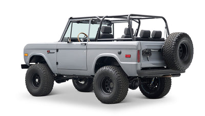 Side profile of a Classic Ford Bronco in gray with black wheels, no roof, and large tires