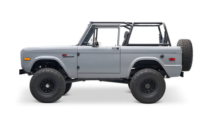 Side profile of a Classic Ford Bronco in gray with black wheels and no roof