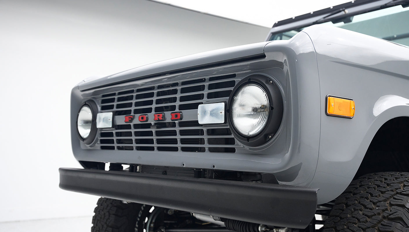 Close-up of front grille and headlights of light gray Classic Ford Bronco