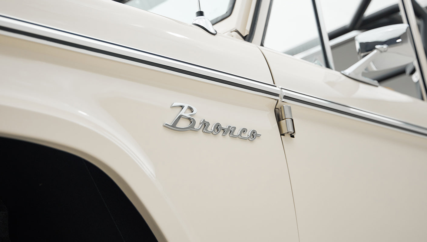 Side view of Classic Ford Bronco showing beige paint and chrome Bronco emblem