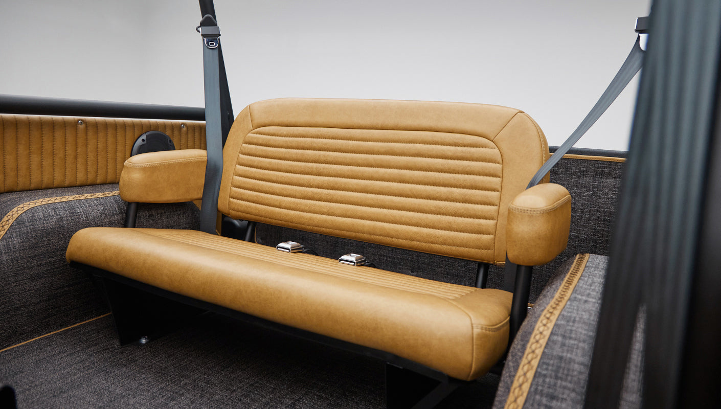 Rear tan leather bench seat with armrests and seat belts inside Classic Ford Bronco