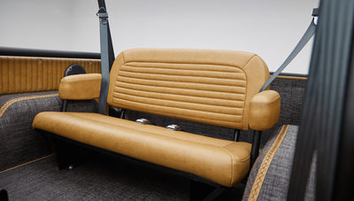 Rear tan leather bench seat with armrests and seat belts inside Classic Ford Bronco