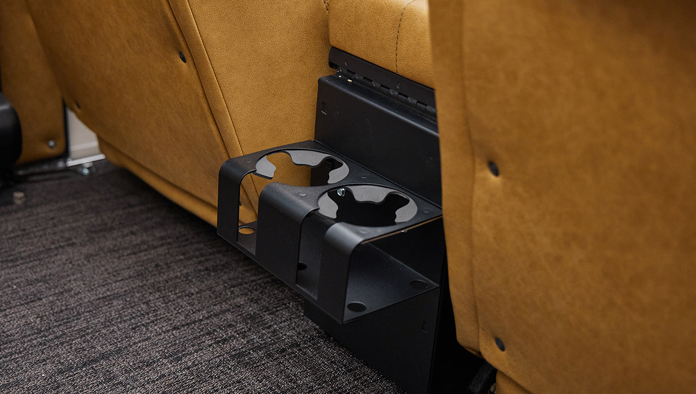 Black rear cup holders attached under tan leather seat inside vehicle