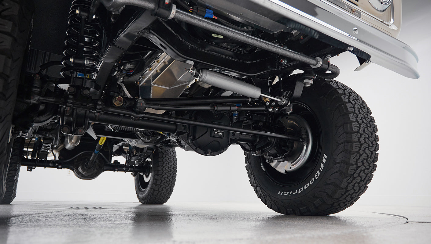 View from underneath of axle, suspension, steering links, and tires on vehicle