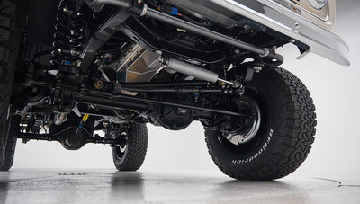 View from underneath of axle, suspension, steering links, and tires on vehicle