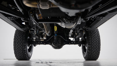 View from underneath showing rear axle, suspension, and tires on vehicle