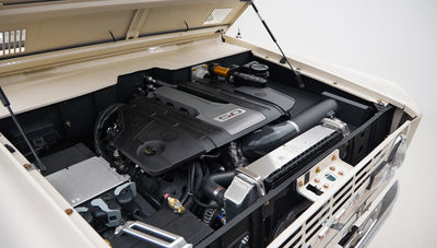Engine bay with 5.0 engine cover and various mechanical components