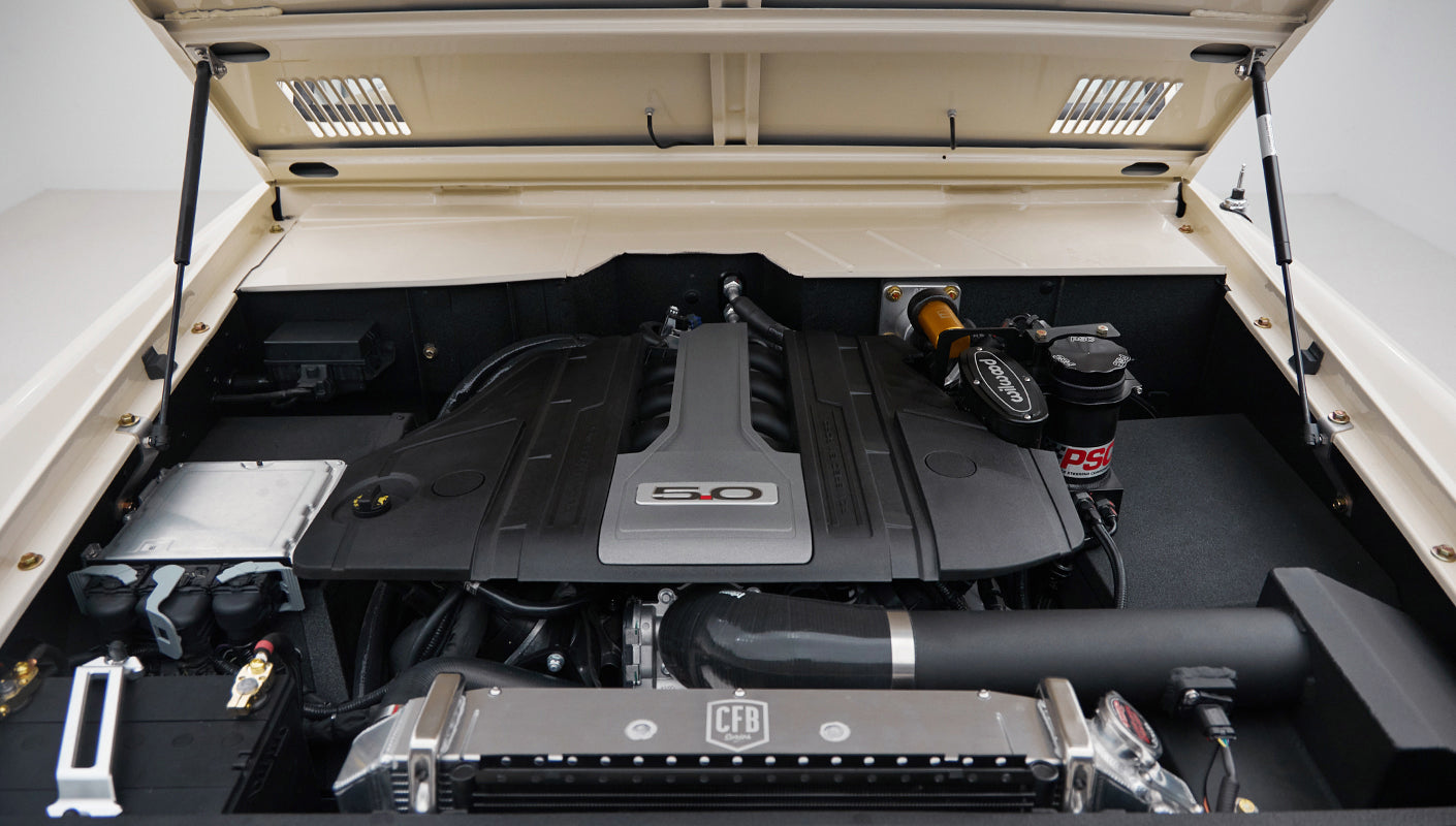 Engine bay showing 5.0 engine cover and cooling system components