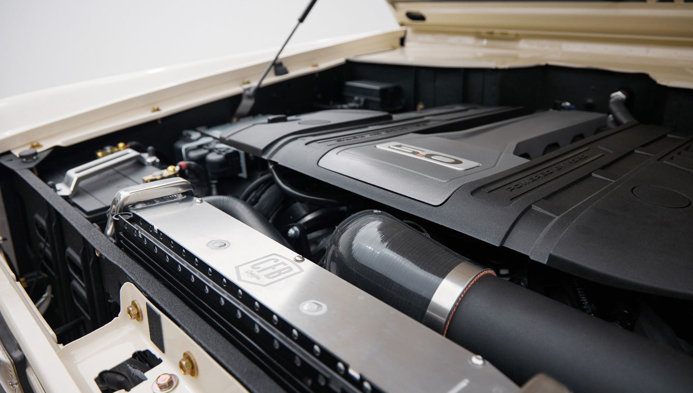 Detailed view of Classic Ford Bronco engine bay with radiator and black intake tubing