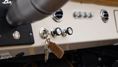 Classic Ford Bronco dashboard controls with metal knobs and keychain hanging from ignition