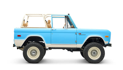 Classic Ford Bronco in heritage blue with beige roof rack and beige interior, side profile view