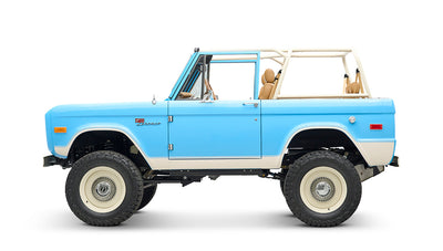 Side profile of Classic Ford Bronco in heritage blue with beige trim and open roof