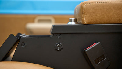 Close view of brown leather seat with heated seat control and seatbelt buckle