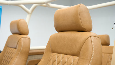 Two brown leather classic Ford Bronco front seats with visible roll cage