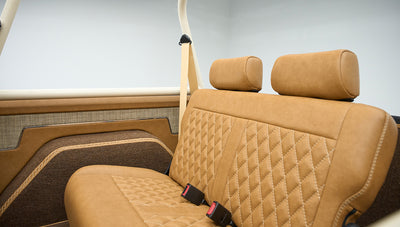 Rear brown leather bench seat with diamond stitching and headrests in classic Ford Bronco