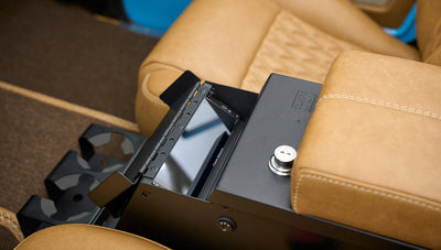 Open central console compartment with small screen inside between brown leather seats