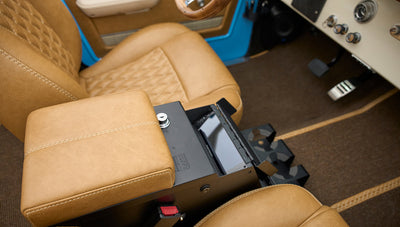 Center console with tan leather armrest and storage compartment inside Classic Ford Bronco