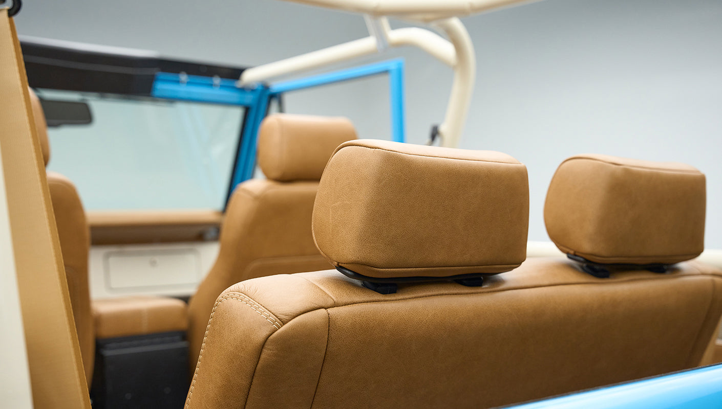 Rear view of tan leather headrests with blue door frame inside Classic Ford Bronco