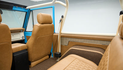 Interior view of Classic Ford Bronco with tan leather seats and blue door frame