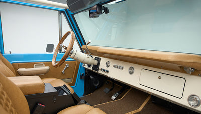 Wide view of Classic Ford Bronco front interior showing steering wheel, seats, and dashboard