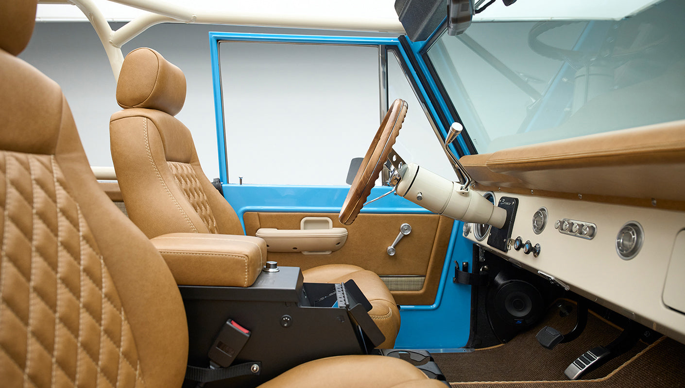 Classic Ford Bronco interior featuring tan leather driver and passenger seats