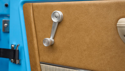 Close-up of manual window crank on tan door panel inside Classic Ford Bronco