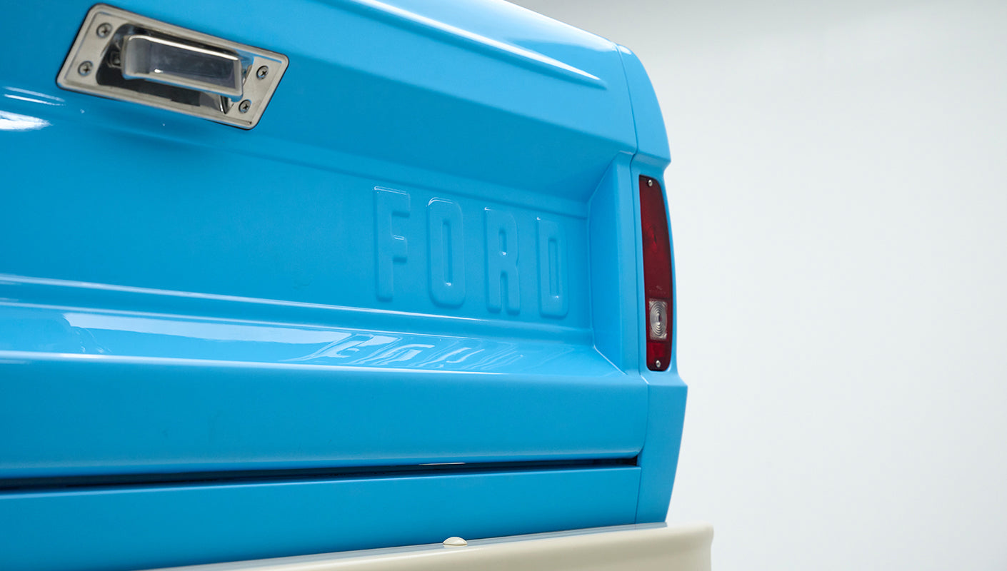 Close-up of tailgate of Classic Ford Bronco painted bright blue with FORD embossed