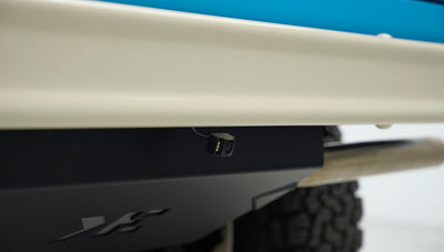 Rearview camera mounted under the beige rear bumper of Classic Ford Bronco