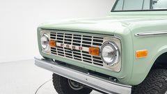 Close-up of front grille and headlights on mint green Classic Ford Bronco
