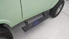 Side step and rear wheel of a light green Classic Ford Bronco