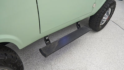 Side step and rear wheel of a light green Classic Ford Bronco