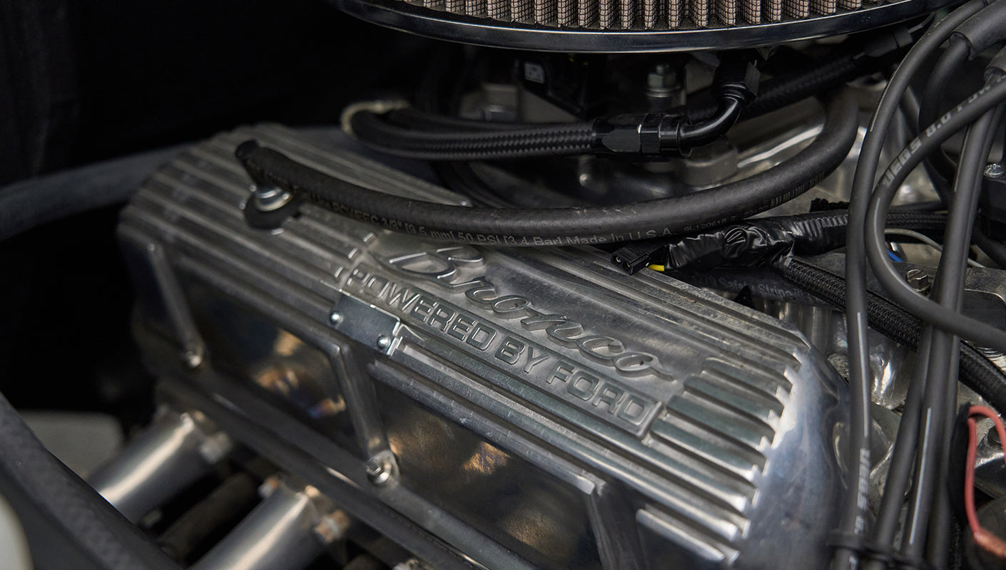 Close-up of a metallic Ford engine component with 'Bronco powered by Ford' embossed