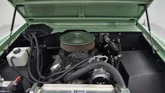 Wide view of engine bay under hood of a Classic Ford Bronco, showing clean engine and radiator components