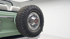 Rear side of a green Classic Ford Bronco with mounted BFGoodrich spare tire