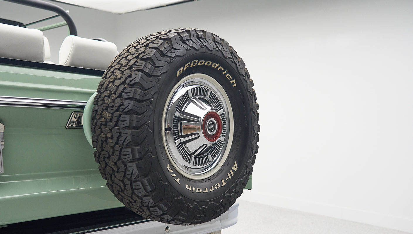 Rear side of a green Classic Ford Bronco with mounted BFGoodrich spare tire