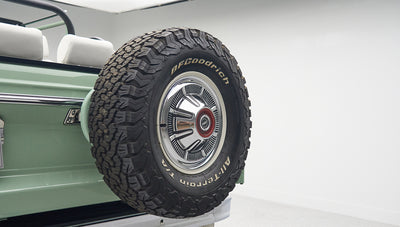 Rear side of a green Classic Ford Bronco with mounted BFGoodrich spare tire