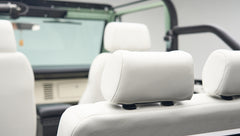 Interior close-up of white leather seats with headrests inside Classic Ford Bronco