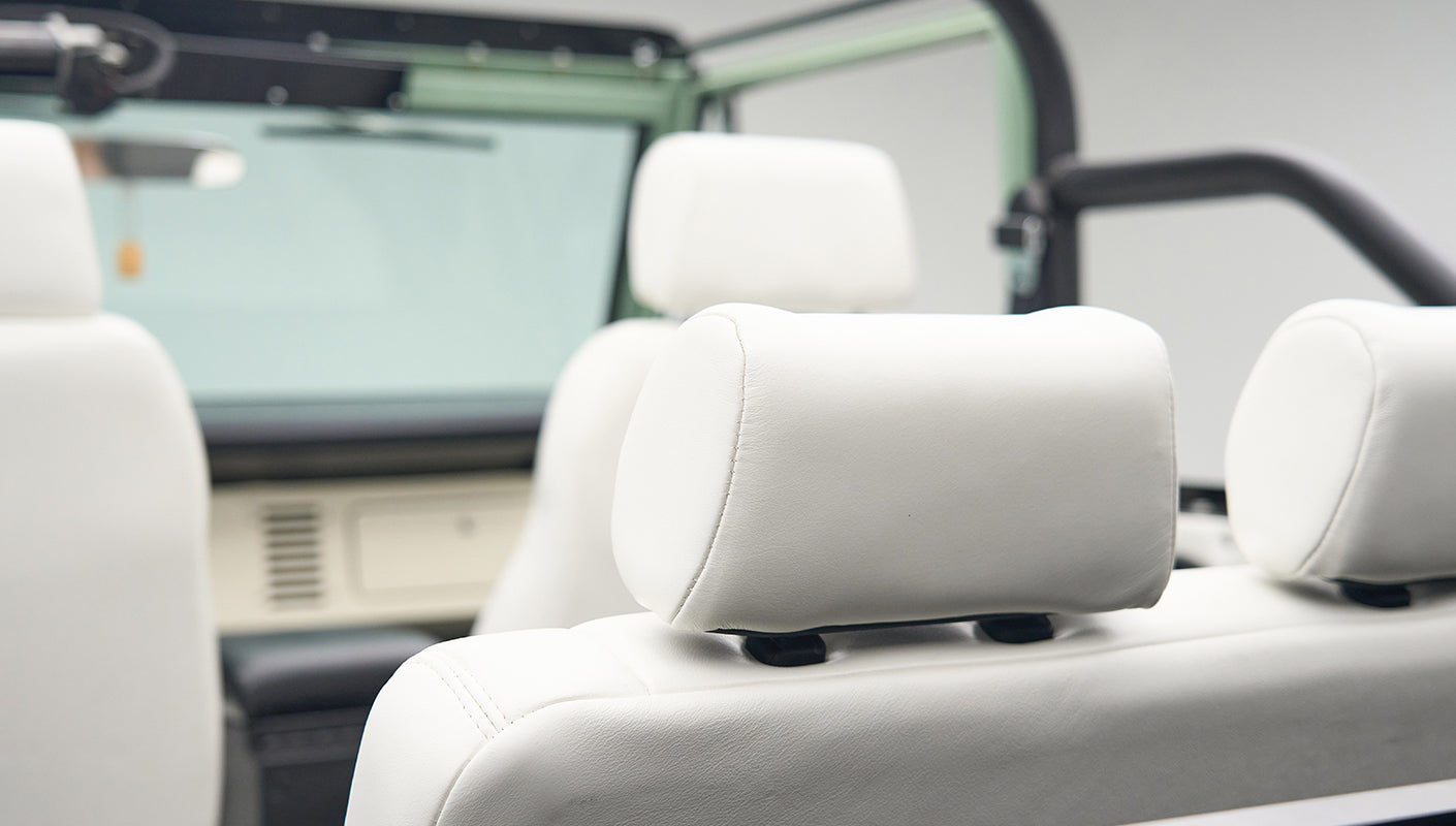Interior close-up of white leather seats with headrests inside Classic Ford Bronco