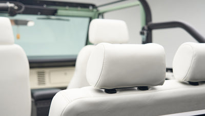 Interior close-up of white leather seats with headrests inside Classic Ford Bronco