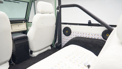 Interior side panel and first row seats of Classic Ford Bronco with roll bar visible
