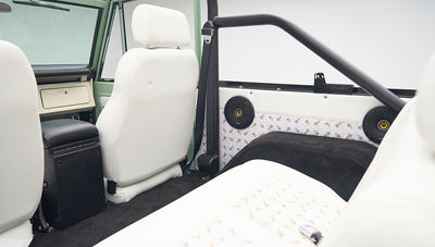 Interior side panel and first row seats of Classic Ford Bronco with roll bar visible