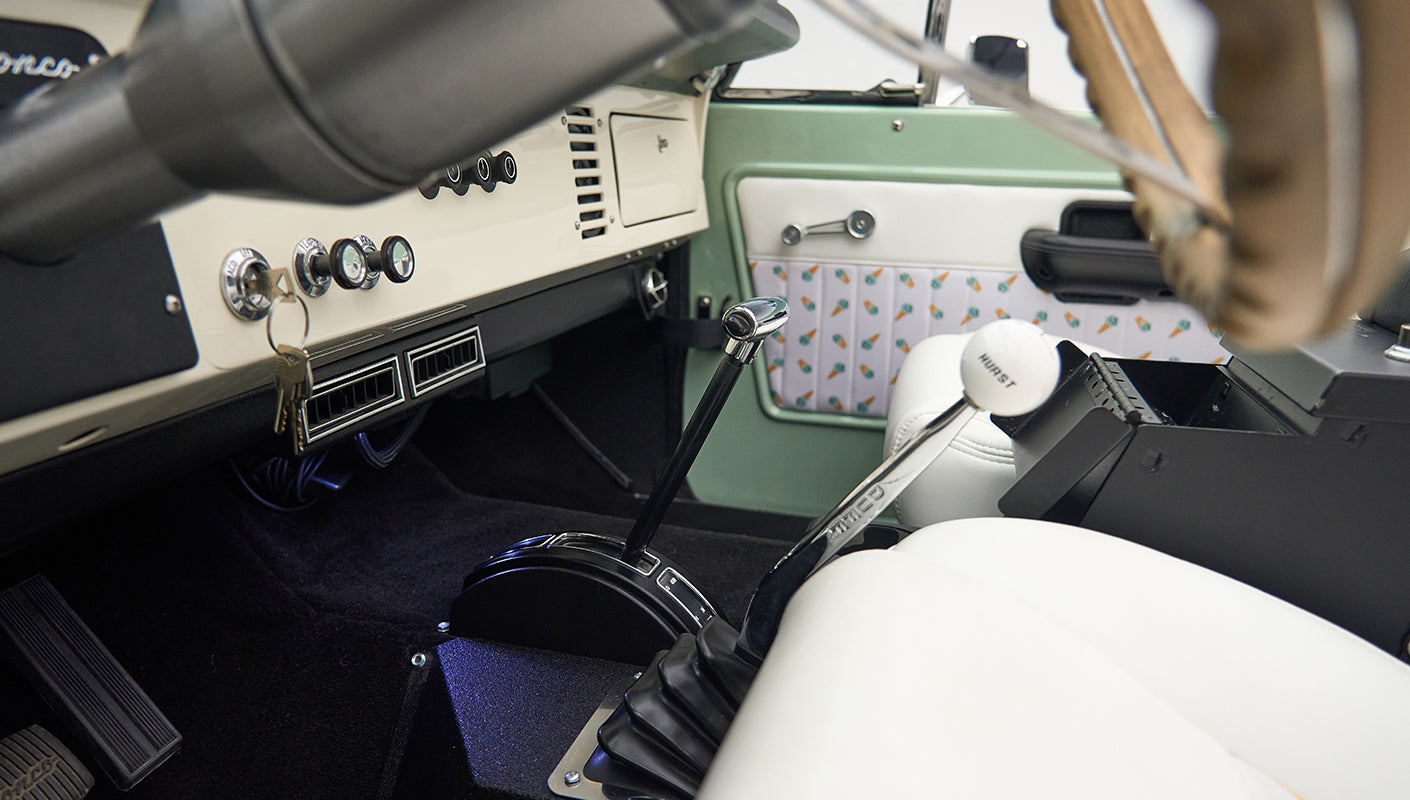 Interior view showing gear shifters and white seat in Classic Ford Bronco