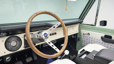 Classic Ford Bronco steering wheel with wooden rim and dashboard