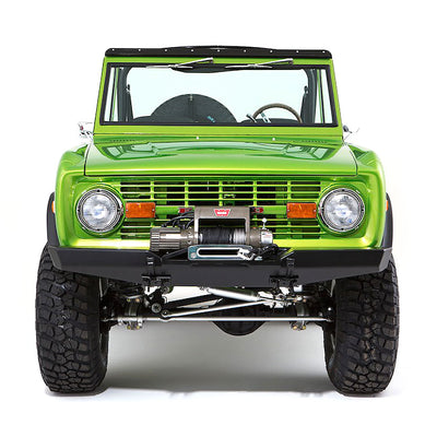 Front view of bright green Classic Ford Bronco with winch and rugged tires on white background