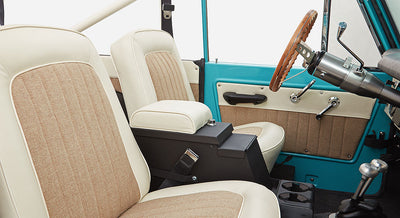 Interior cabin side view of Classic Ford Bronco showing two front seats and steering wheel