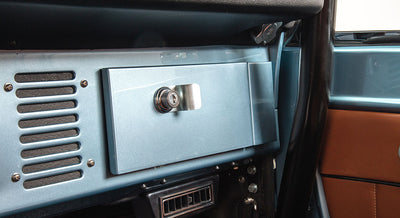 Light blue Classic Ford Bronco dashboard close-up with glove box and vent