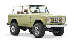 Front view of lime green Classic Ford Bronco with lifted suspension and tan roll cage