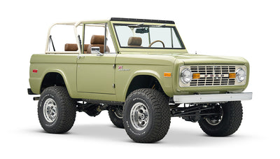 Front view of lime green Classic Ford Bronco with lifted suspension and tan roll cage