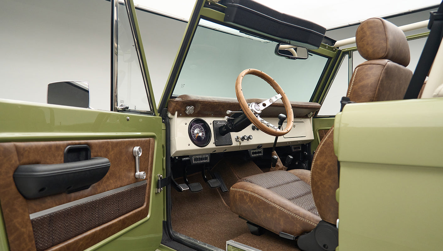 Interior view of Classic Ford Bronco driver's seat and steering wheel with open door