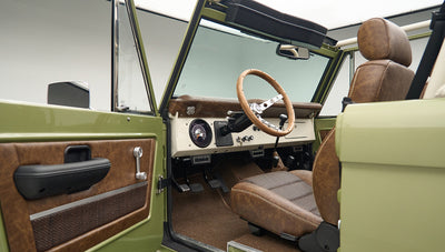 Interior view of Classic Ford Bronco driver's seat and steering wheel with open door